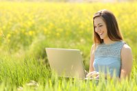 Young woman working outside on laptop