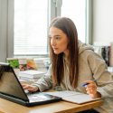 Female student studying laptop screen intently