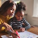 Mother and daughter studying together at table