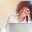 Stressed young female professional at laptop