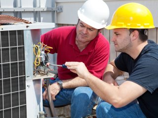 HVAC Technicians working on an A/C unit