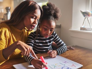 Mother and daughter studying together at table